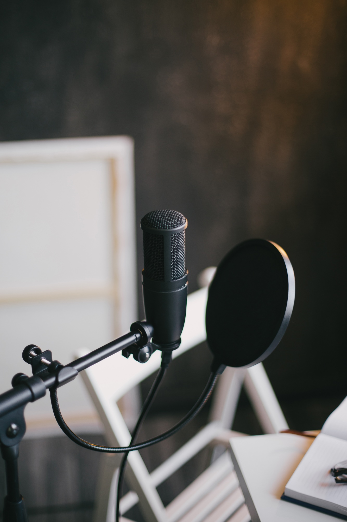 Professional equipment for recording podcast: microphone, earphones and laptop in a studio.